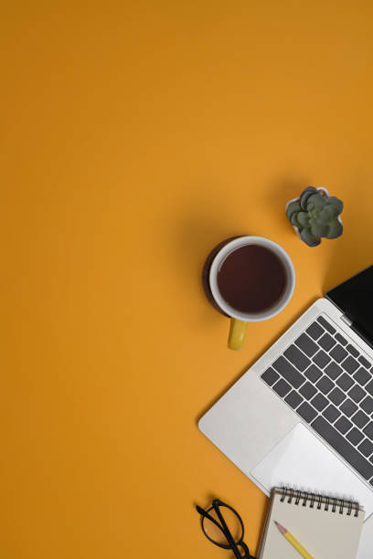 istock From above view laptop computer, coffee cup and notebook on yellow background with copy space for your text. 1393088357