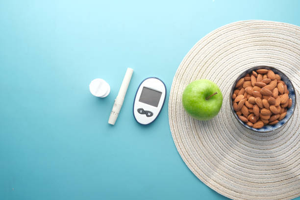 istock diabetic measurement tools, almond nut and apple on table 1393089498