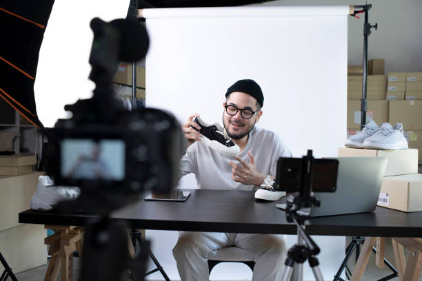 Asian man blogger or vlogger looking at camera reviewing product. Young attractive Asian man blogger or vlogger looking at camera reviewing product. Modern businessman using social media for marketing. Business online influencer on social media concept. vlogging stock pictures, royalty-free photos & images
