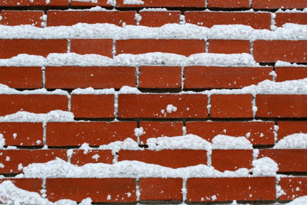 istock Texture of a red brick wall covered with snow 1393090579