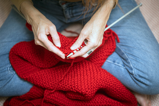 hobbies and leisure. girl knits a red scarf\