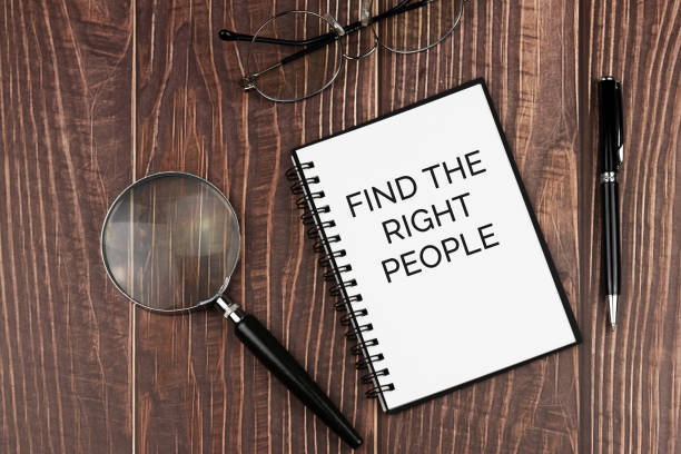 Find the right people text on note pad with calculator and pen on wood background concept stock photo