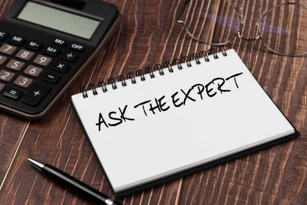 istock Ask the expert text on note pad with calculator and pen on wood background concept 1393093014