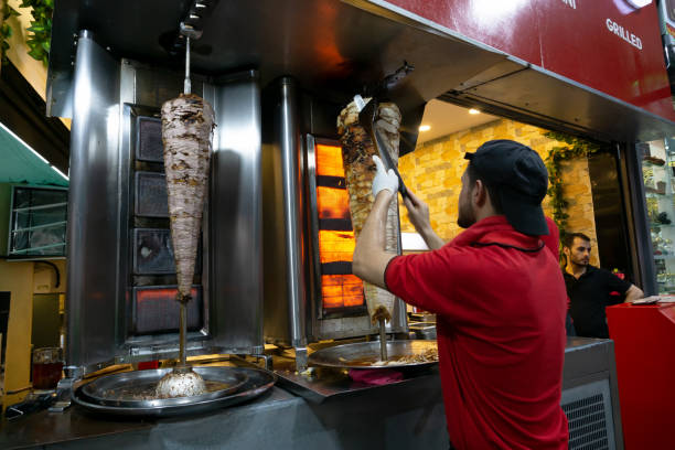 Kuala Lumpur, Malaysia - Feb 15, 2018: Man cutting roasted kebab meat with doner knife in Kuala Lumpur Malaysia.