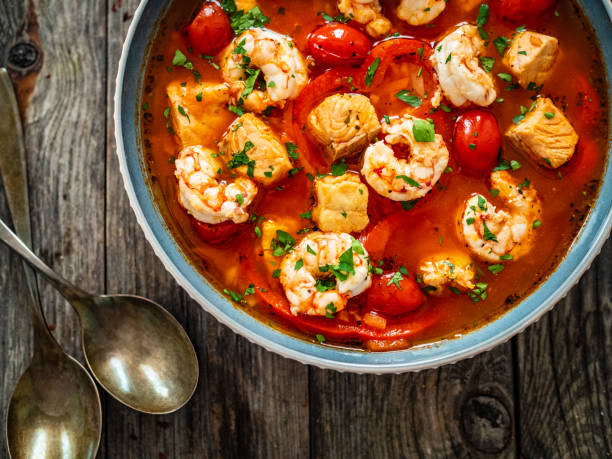 istock Fish soup with prawns and tomatoes on wooden table 1393094513