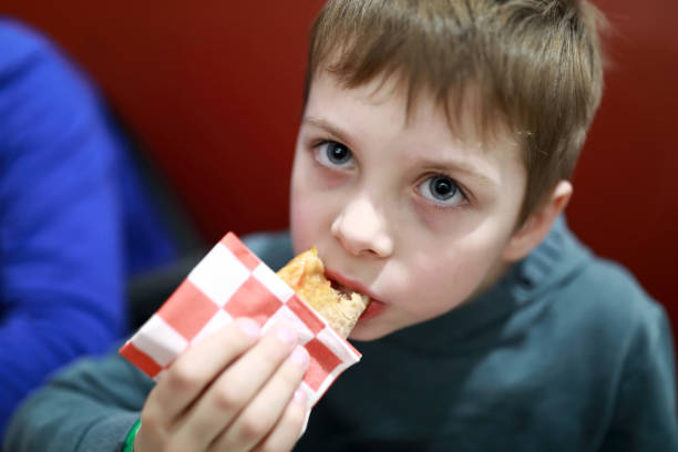 istock Child eating pizza in restaurant 1393095056