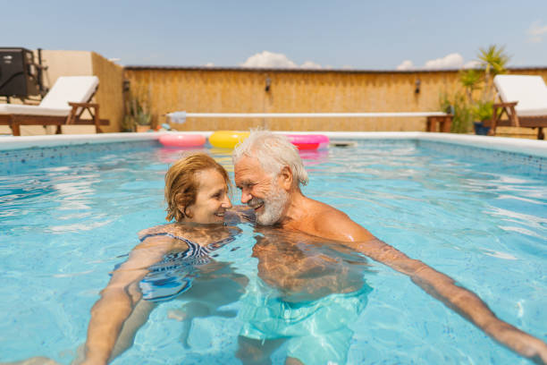 istock Senior couple refreshing in the swimming pool 1393097732