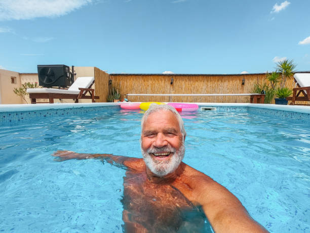 istock Senior man taking a selfie from swimming pool 1393097765