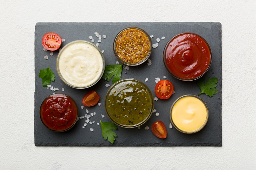 Many different sauces and herbs on table, flat lay top view. sauces on plate, healthy concept.