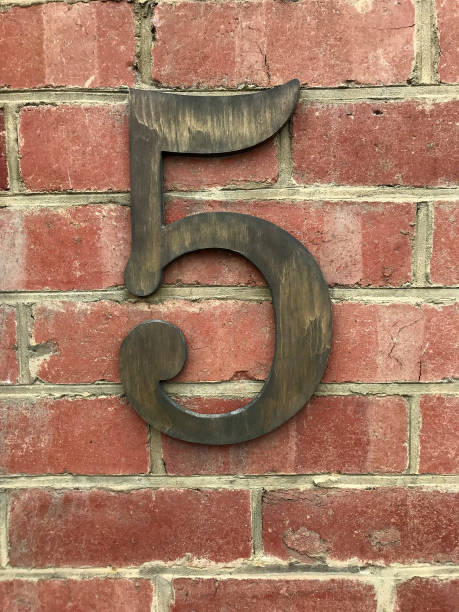 istock Large brass number five mounted on a red brick wall 1393099728