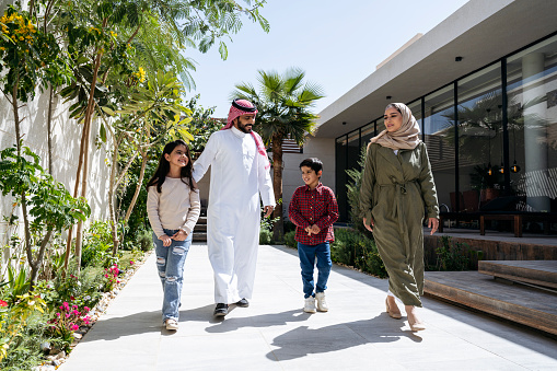Niños saudíes caminando al aire libre con sus padres photo