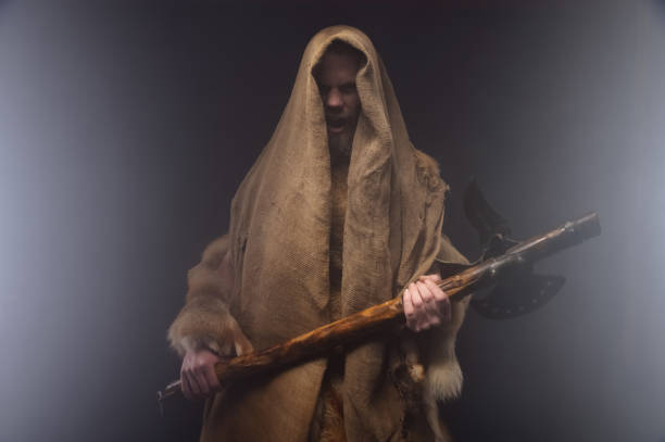 istock Ancient Slavic warrior-mage. Cloud of smoke on a black background. Mystical ancient character with ancient weapons. studio atmospheric portrait 1393104436