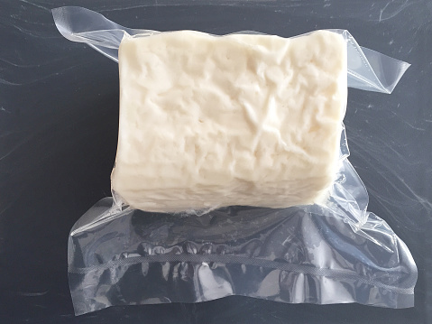 Transparent plastic package of white feta cheese