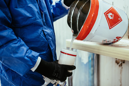 Painter in painting chamber, applying paint on semi conducted parts