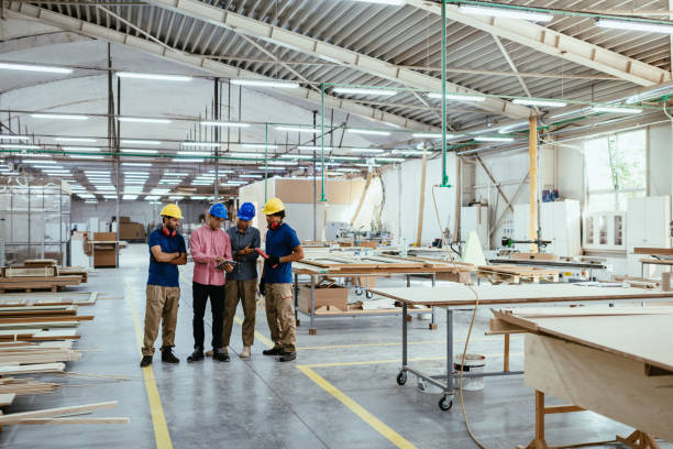 istock Architects, engineers and blue collar staff working together in modern factory 1393109831