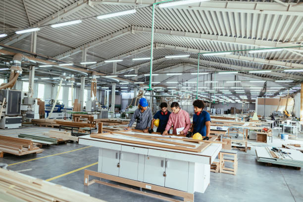 istock Architects, engineers and blue collar staff working together in modern factory 1393110916