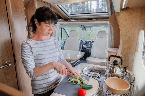 istock Woman cooking in camper, motorhome interior 1393111618