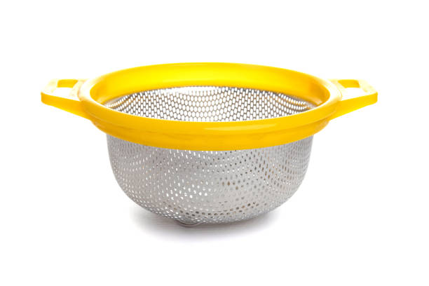 Metallic kitchen utensils hanging on kitchen ventilation duct.