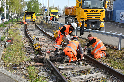 Basel, Switzerland - April 2022: Railway workers repairing track on a railway line in the city's docks area