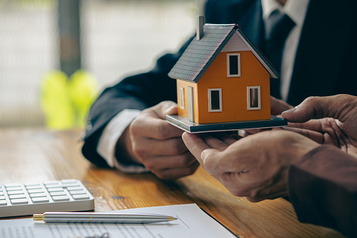 Real estate agents present and consult with clients to decide whether to sign home insurance contracts on mortgage deals, sales managers offer homes to clients for leasing and selling.