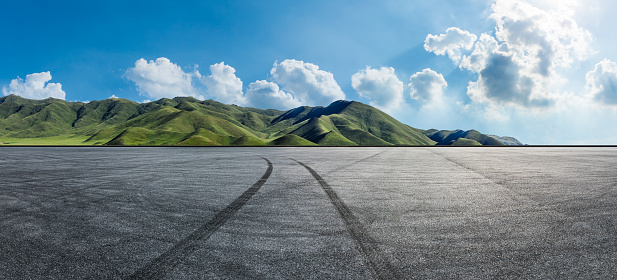 Empty asphalt road and mountain nature scenery under blue sky. Road and mountains background.