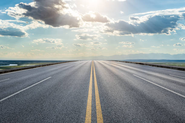 istock Asphalt road and sky clouds at sunrise 1393121894