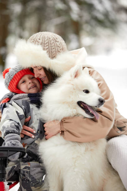 istock Mother and son child walking with white Samoyed dog in winter day 1393123711