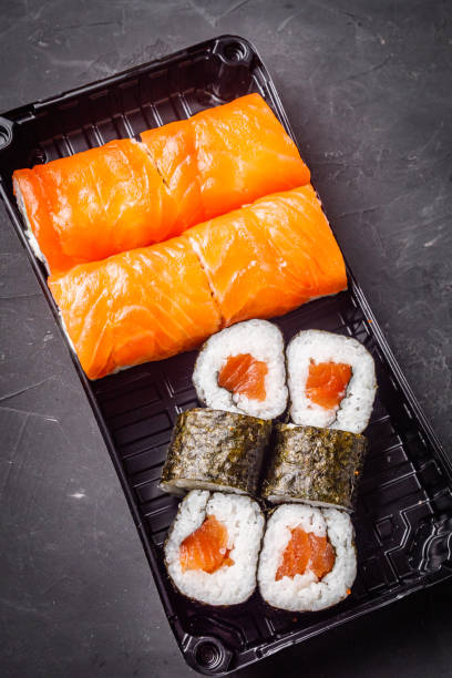 istock delicious sushi rolls in a delivery box on a black background 1393124025