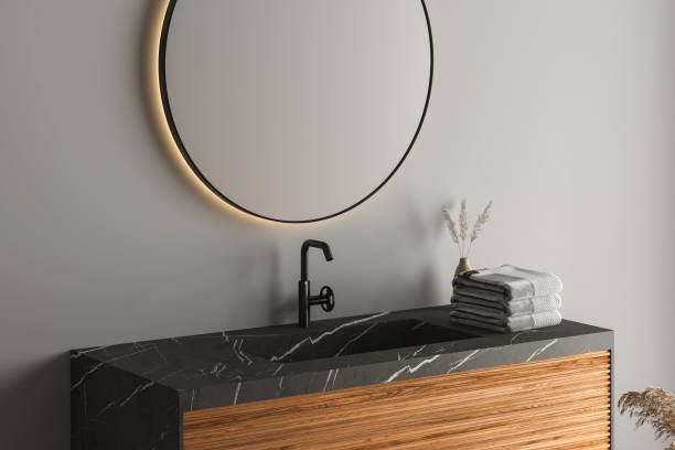 istock Close up of basin with oval mirror standing in on grey wall 1393125020