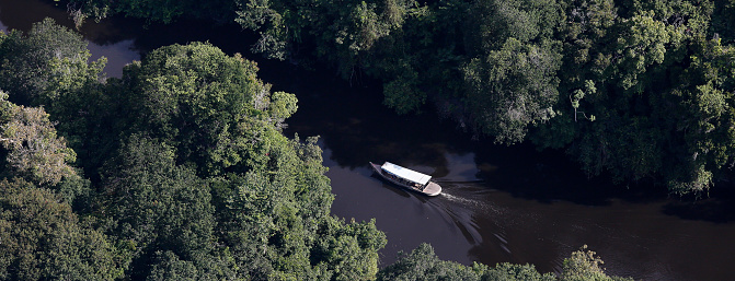 Aerial view of boat crossing a river in the Amazon in Brazil. Combu Island, Ilha do Combu, Belém, Pará State, Amazon, Brazil. 2013.