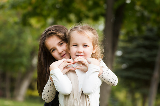 two sisters child girls   embrace, playing  and  having fun together  outdoor