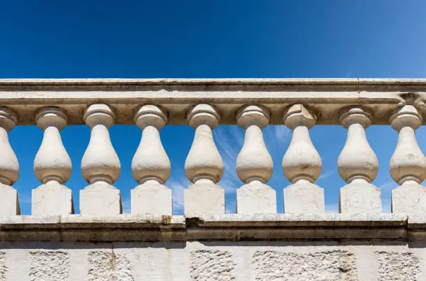 Close-up of a white marble balustrade in classical style against a clear blue sky and copy space. Brescia downtown, Lombardy, Italy, Europe.