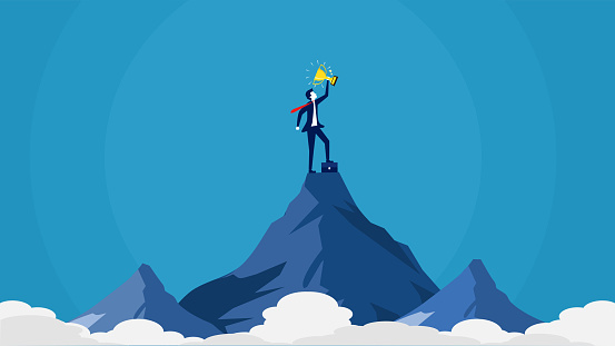 Businessman holding a trophy on top of a mountain. success concept