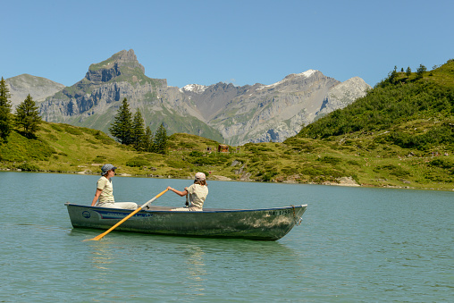 Engelberg, Switzerland - 8 August 2020: tourists rowing in their boat at lake Truebsee above Engelberg on the Swiss Alps