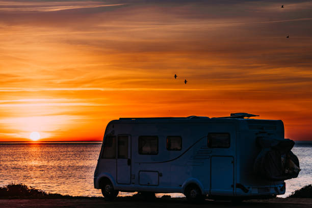 istock Camper vehicle on beach at sunrise 1393134012