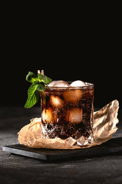 Cocktail with whiskey and cola Cocktail with whiskey and cola decorated with mint leaf cuba libre stock pictures, royalty-free photos & images