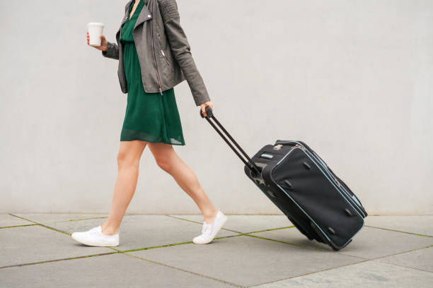 Solo traveler walking with a suitcase on the street stock photo