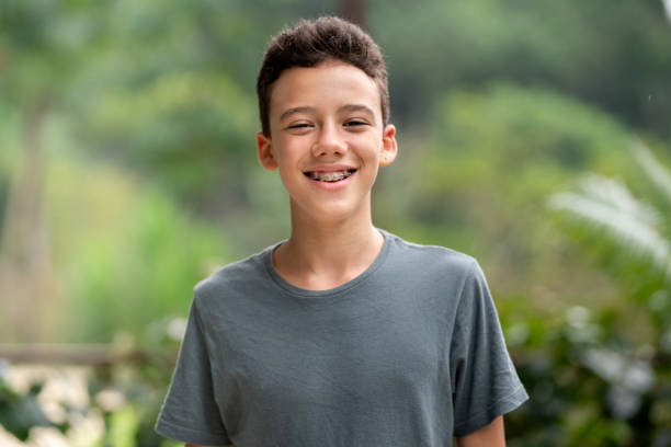 teen boy with braces smiling outside in summer - smiling boy imagens e fotografias de stock