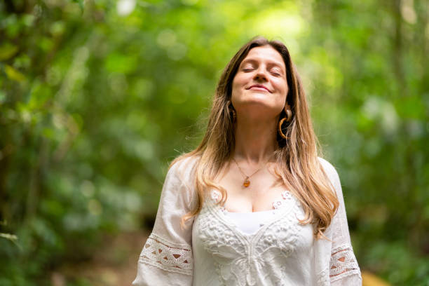 istock Smiling young woman standing in a forest with her eyes closed 1393138204