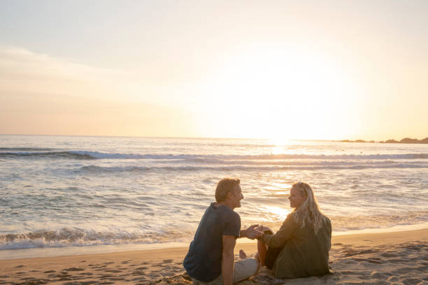 istock Couple share digital tablet on beach at sunset 1393141488