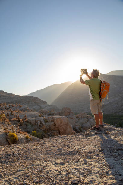 istock Hiker takes photo with digital tablet at sunrise 1393141763