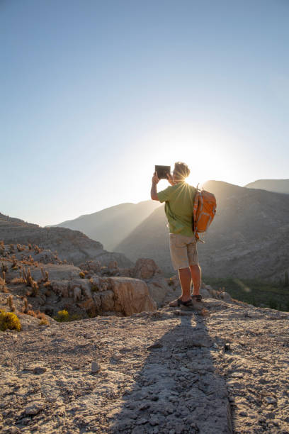 istock Hiker takes photo with digital tablet at sunrise 1393142273