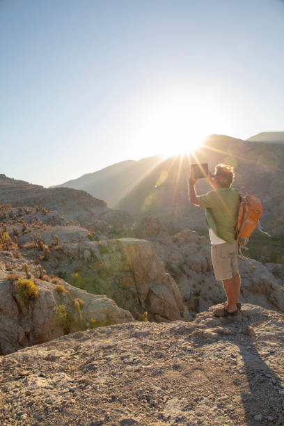 istock Hiker takes photo with digital tablet at sunrise 1393142274