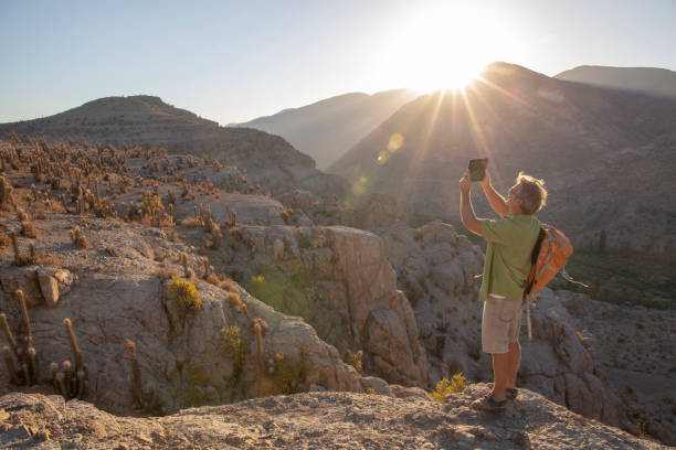 hiker takes photo with digital tablet at sunrise - travel ipad isolated backpack imagens e fotografias de stock