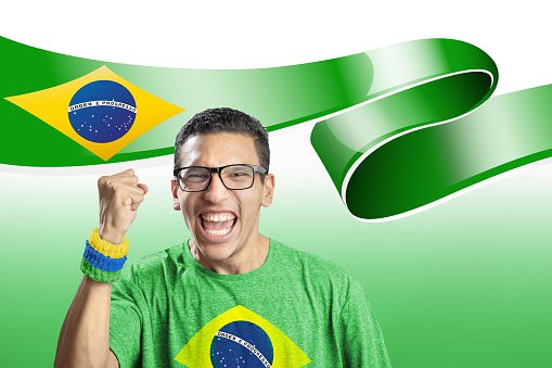 Soccer fan national team of Brazil celebrating goal with brazilian flag