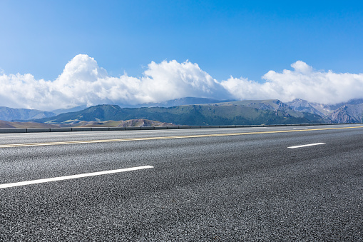 Asphalt road and mountain with sky clouds background