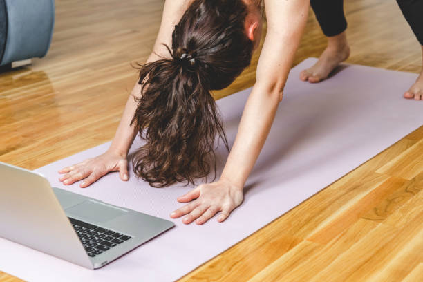 istock Woman doing online yoga on exercise mat. 1393146280