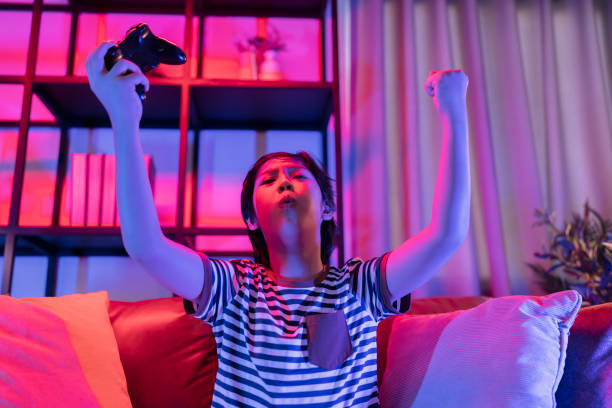 istock Exited smiling cheerful asian Teenager boy playing mobile game smartphone application on sofa in living room at home,Asian child male Sitting on a couch using smartphone having fun playing a game on mobile at night 1393146880