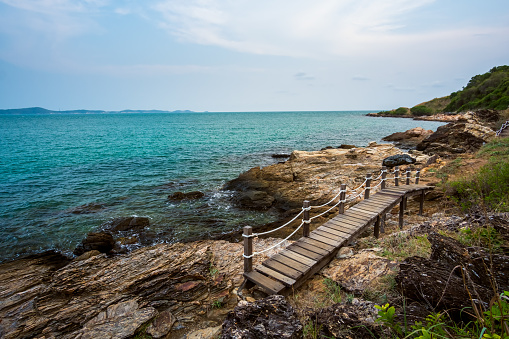 Wood bridge in to the sea and sea rocks, sidewalk on the beach at Khao Laem Ya Moo Koh Samed National Park, Rayong, Thailand.