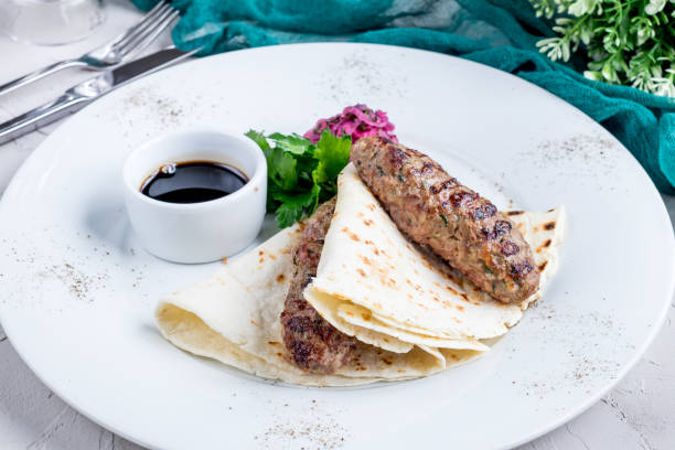 istock Lamb Lula kebab with red onion and sauce on a white plate 1393149730
